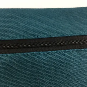 Detailaufnahme einer blauen Leinentasche mit feiner Textur und robustem schwarzen Reissverschluss.