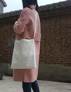 Detailansicht der weißen, blanko Canvas Tragetasche, ideal für DIY Malerei, lässiger Alltagsstil.