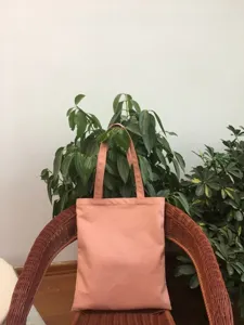 Detalle de bolso tote de lona rosa, bolsa de compras lisa para uso diario escolar.