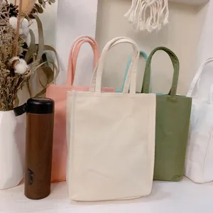Detail view of colorful canvas tote bags and water bottle bags, simple and practical design.