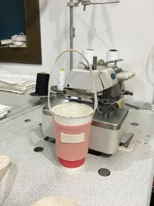 Detailansicht des rosa Stoffbechers mit Tragegurt, der die Textur und Verarbeitung zeigt.