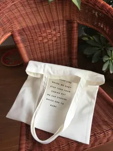 White canvas tote bag with inspirational text, eco-friendly casual shopping shoulder bag.