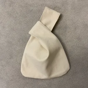 Detailansicht der Canvas Handgelenktasche, minimalistischer beigefarbener Knotengriff Beutel.