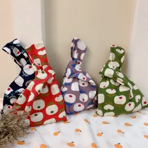Close-up detail of Japanese style cotton knot wrist bag with floral print, casual handbag design.