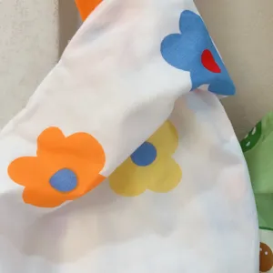 Nahaufnahme der floralen Leinwand-Handgelenktasche und des bunten Stoffes im japanischen Stil.