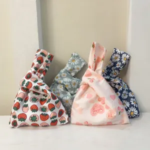 Japanese style fabric knot wrist bag featuring cute floral and fruit prints for daily wear.
