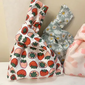 Japanese style fabric knot wrist bag featuring cute strawberry and floral prints, ideal for daily use.