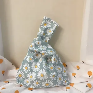 Japanische Stoff Knoten Handtasche Detail Ansicht mit Gänseblümchen Muster und Henkel.
