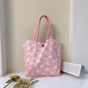 Nahaufnahme der rosa Leinentasche mit süßem Kaninchenmuster und robusten Griffen.