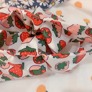 Close-up detail view of the cute strawberry print fabric on this Japanese style knot wrist bag.