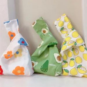 Nahaufnahme von japanischen Stoff-Knotentaschen mit niedlichen Blumen- und Frucht-Prints.