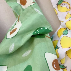 Süßes Frucht-Handtaschen-Stoffmaterial mit grünem Avocado- und gelbem Zitronen-Design.