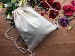 Plain canvas drawstring backpack for DIY hand painting, solid off-white fabric storage bag.