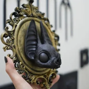 Détail de sculpture murale chauve-souris en résine gothique, cadre doré vintage, déco effrayante.