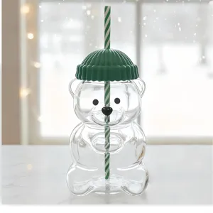 Cute glass teddy bear straw cup detail view, transparent bear shape cup with green lid.