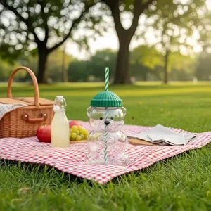 Cute clear glass bear straw cup with green lid and striped straw for daily drink use.