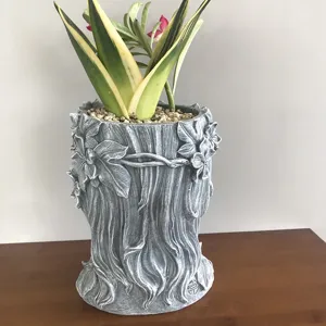 Resin goddess face flower pot detail, artistic tree sculpture planter for succulent plants.