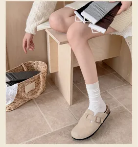 Nahaufnahme von gestrickten gerippten Socken kombiniert mit Velourslederschuhen im Alltag.