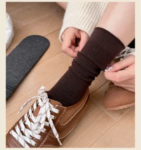 Nahaufnahme brauner gerippter Mittelsocken im Lagenlook mit stylischen Retro-Sneakern.