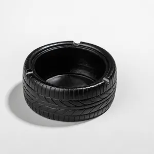 Vue détaillée du cendrier noir en forme de pneu, décoration de bureau créative.