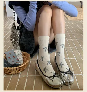 Calze con stampa fiocco vintage abbinate a ballerine argento con punta divisa, stile unico.