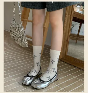 Calze al polpaccio stile retrò giapponese con fiocco abbinate a scarpe tabi argento.