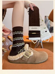 Primo piano dettagliato di calze invernali lavorate a maglia abbinate a comode scarpe peluche.