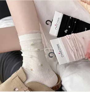 Nahaufnahme von dünnen Damen Socken mit Blumenmuster, weißer Spitze und lockerem Stil.