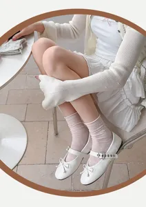 Close-up detail of sweet sheer mid-calf socks with delicate hollow bow and heart patterns.