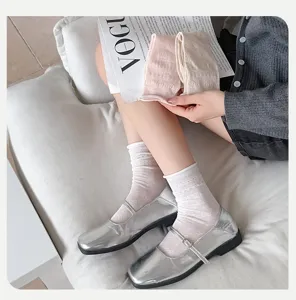 Detailed view of sweet Japanese style hollow bow mid-calf socks paired with silver shoes.