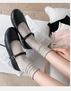 Detail view of Japanese style textured mid tube socks paired with classic black Mary Jane shoes.