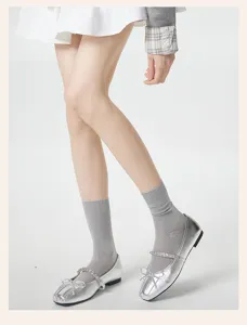 Ademende transparante halflange sokken voor dames, gecombineerd met elegante zilveren schoenen.