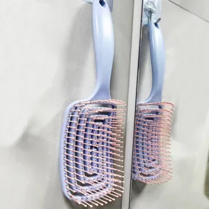 Curved vented hair brush with flexible bristles for scalp massage and quick blow drying at home.