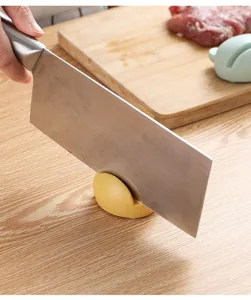 Detail of mini frog knife sharpener in use, compact kitchen tool for quick sharpening.