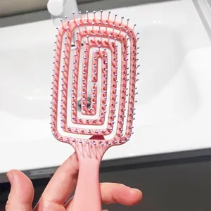 Pink curved vent hair brush with spiral hollow design for daily scalp massage and fluffy hair styling.