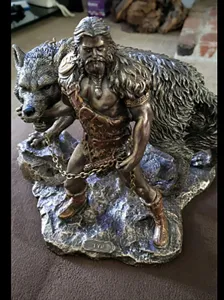 Detailed close-up of the Norse god Tyr resin figurine with wolf sculpture and rocky base.