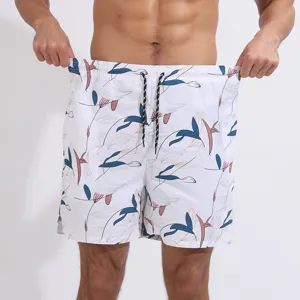Dettaglio in primo piano di pantaloncini da bagno bianchi da uomo con stampa botanica.