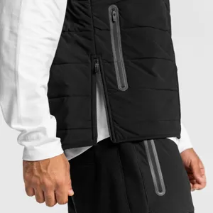 Close-up detail of black padded puffer vest featuring waterproof zipper and side slit design.