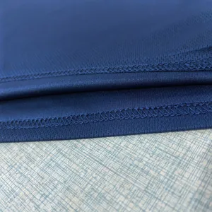 Vue détaillée du tissu de t-shirt de sport en maille bleue respirante avec ourlet précis.