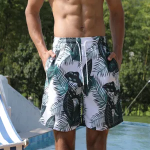 Detailed view of men's tropical leaf print quick-dry beach shorts with drawstring waist.