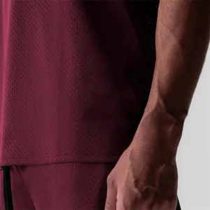 Burgundy mesh athletic tank top detail view showing breathable fabric and sleeveless design.