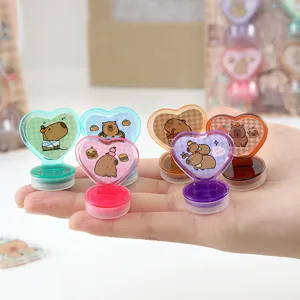 Detailed shot of cute heart-shaped capybara stamps with colorful ink pads, stationery gift.