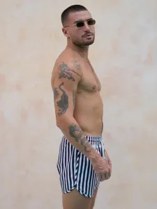 Close-up view of men's black and white striped quick-drying beach shorts fabric detail.