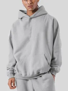Sweat-shirt a capuche en molleton gris uni oversize presente par le modele principal.