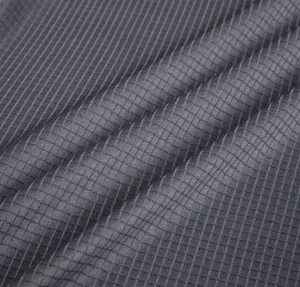 Close-up detail of grey breathable quick-dry fabric with grid texture for sportswear.