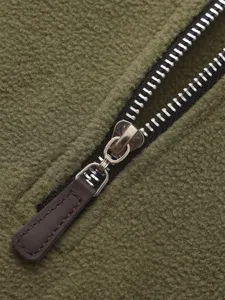 Λεπτομέρεια fleece τζάκετ με μεταλλικό φερμουάρ και καφέ δερμάτινο λουράκι.