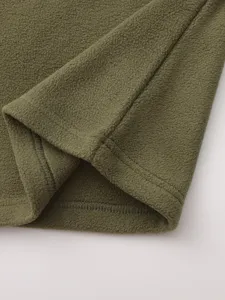 Λεπτομέρεια πράσινου υφάσματος fleece, απαλή υφή και καθαρές ραφές για ρουχισμό.