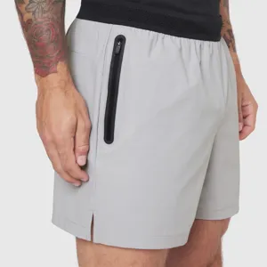 Men's sports shorts detail view featuring black zipper pocket and elastic waistband.