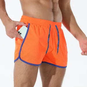 Vista dettagliata pantaloncini sportivi rete arancioni uomo con bordi e coulisse blu.