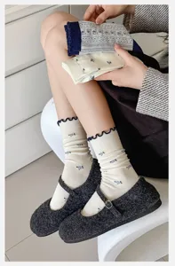 Detailansicht japanischer Vintage-Blumen-Socken mit süßem Rüschenrand und marineblauem Design.